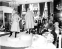  Models wearing rain macs and knee high boots at a fashion show for Dickins and Jones, c.1960s.